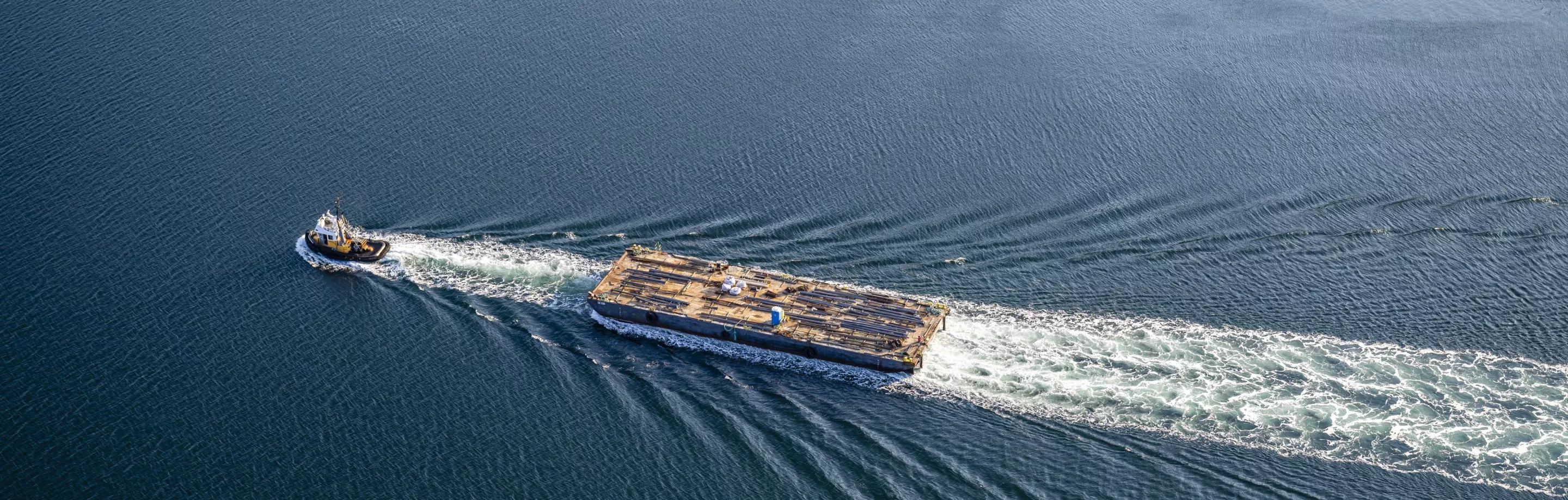 Un remorqueur tirant une barge, vu d'en haut
