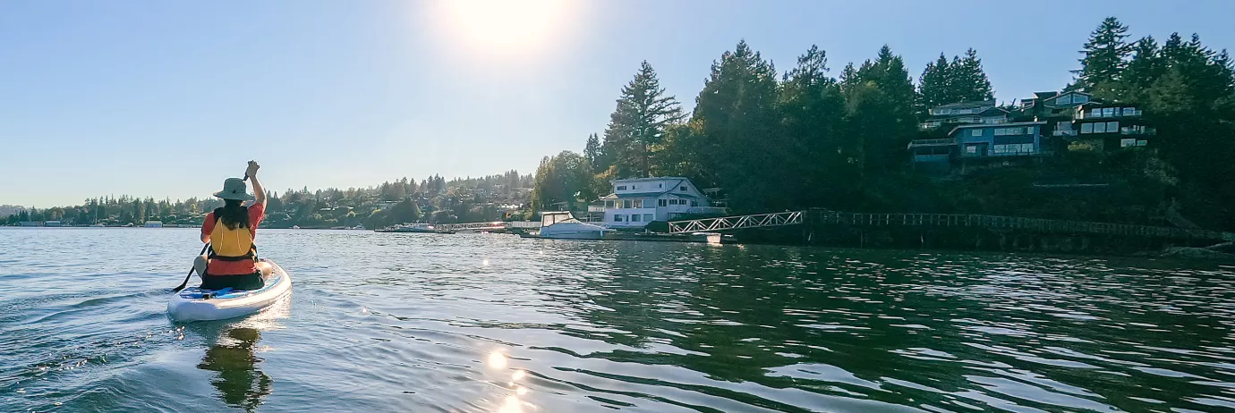 Paddle boarder along a waterway